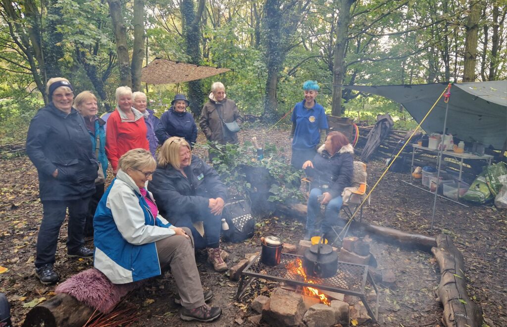 Clay  Cross Health walking group sitting in front of a fire at Kenning park.
