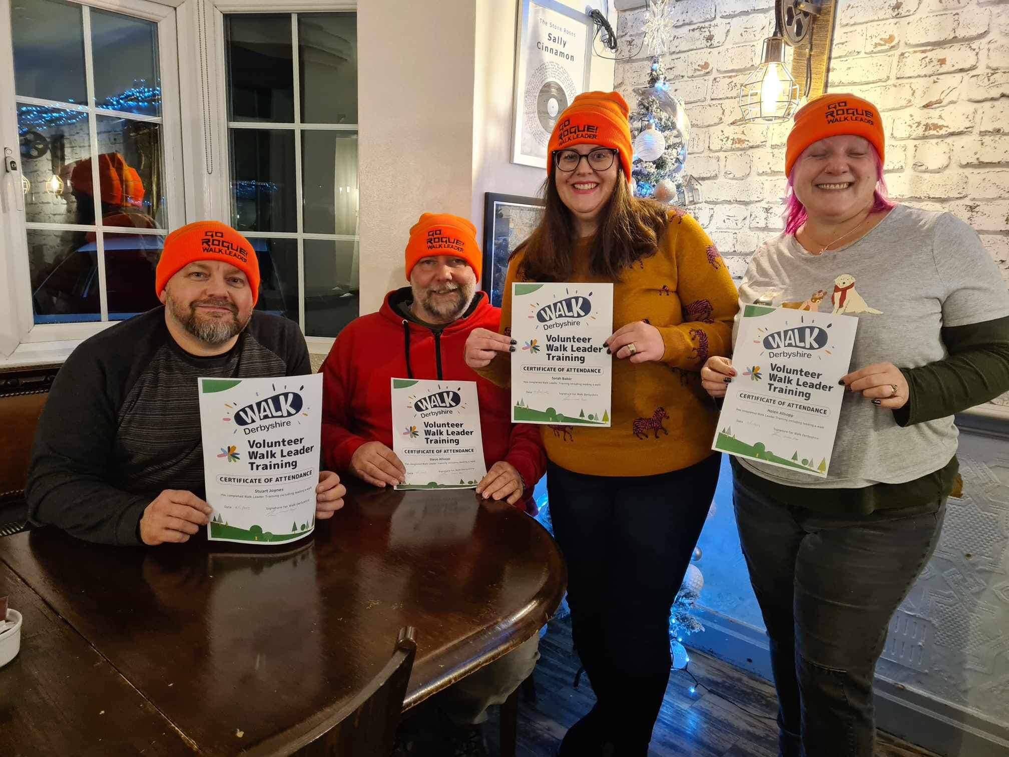 Four newly trained walk leaders holding their certificates